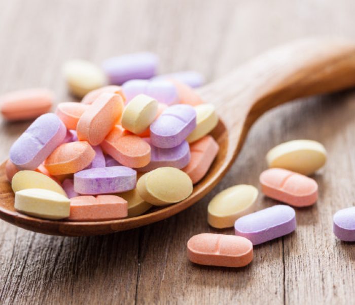vitamin-pills-wooden-background_43937-40